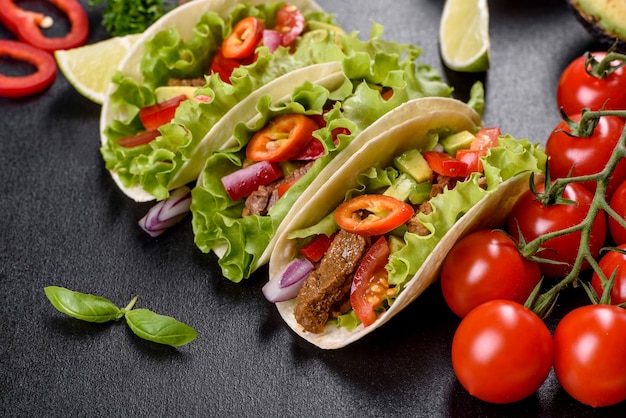 Tacos mexicains avec boeuf, tomates, avocat, oignon et sauce salsa