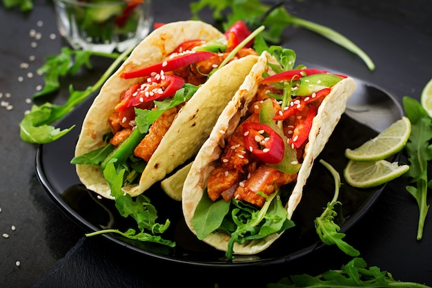 Tacos mexicains avec filet de poulet à la sauce tomate et salsa de paprika et de roquette.