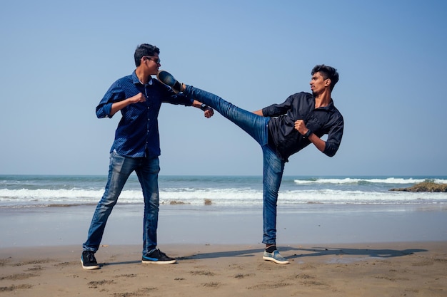 Taekwondo de formation des deux jeunes hommes indiens sur la plage de Goa