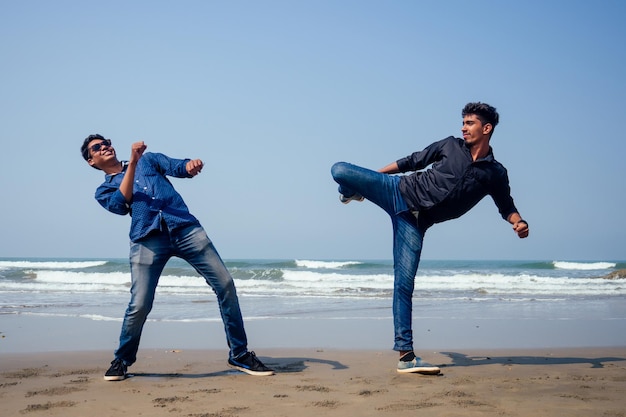 Taekwondo de formation des deux jeunes hommes indiens sur la plage de Goa