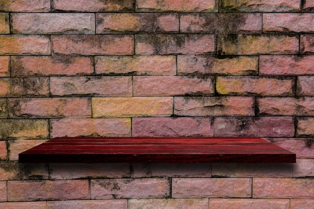 Étagère en bois vide sur le mur de briques.