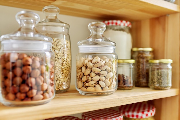 Étagères en bois de garde-manger de cuisine avec bocaux et récipients avec stockage des aliments