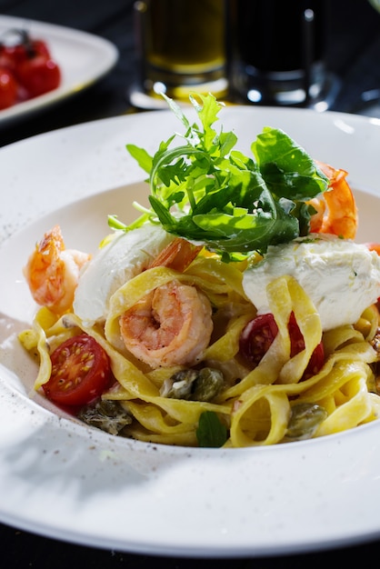 Tagliatelles aux crevettes, roquette, tomates et fromage Philadelphie.