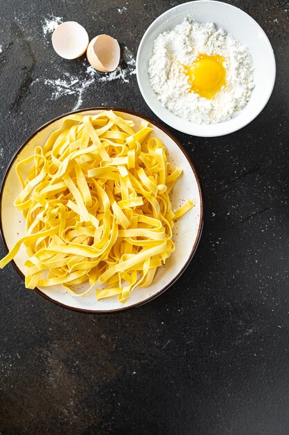 Tagliatelles aux œufs de pâtes crues cuisson à la main repas de blé dur collation sur la table copie espace nourriture