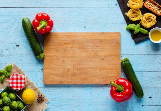 Tagliatelles de pâtes au pesto et autres légumes sur un fond de bois.