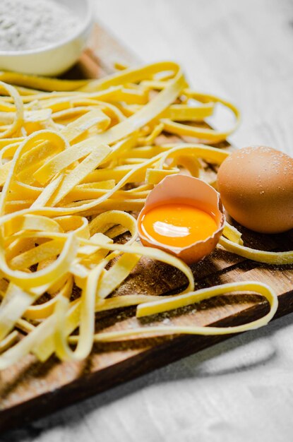 Photo des tagliatelles de pâtes faites maison sur une table blanche