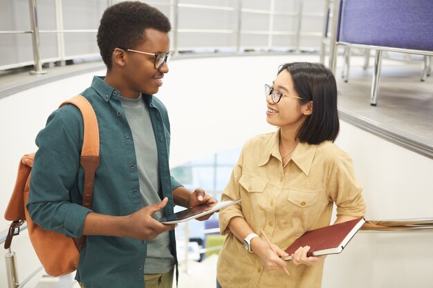 Taille portrait de couple d'étudiants internationaux bavardant