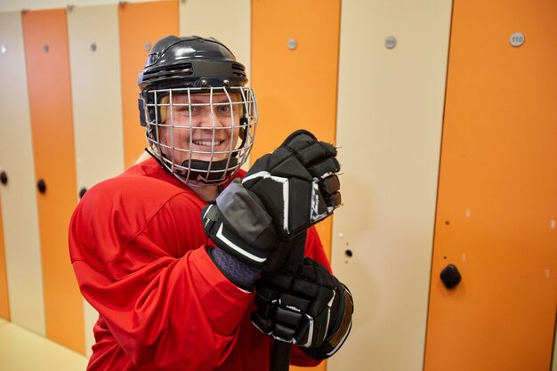 Taille portrait de joueur de hockey féminin portant un équipement complet souriant