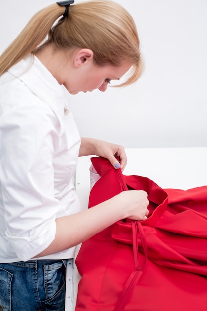 Tailleur coud une robe rouge