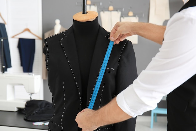 Tailleur prenant des mesures de mannequin en atelier