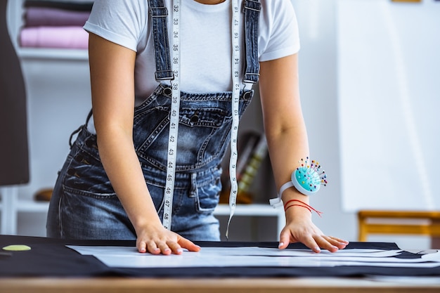 Le tailleur travaillant avec un tissu sur la table