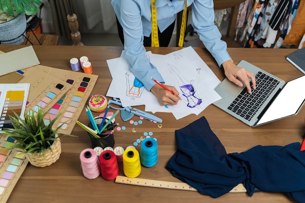 Le tailleur travaille à son meilleurLes designers professionnels coupent des vêtements à la mode dans le studio de designCréativité et idées