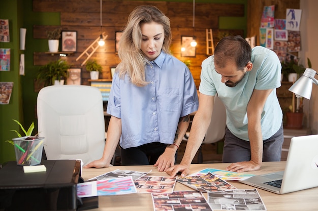 Une tailleuse et une créatrice de mode ciblées partageant des idées dans un bureau de création.