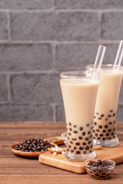 Taïwan populaire boit du thé au lait à bulles avec boule de perles de tapioca dans un verre à boire et une table en bois de paille