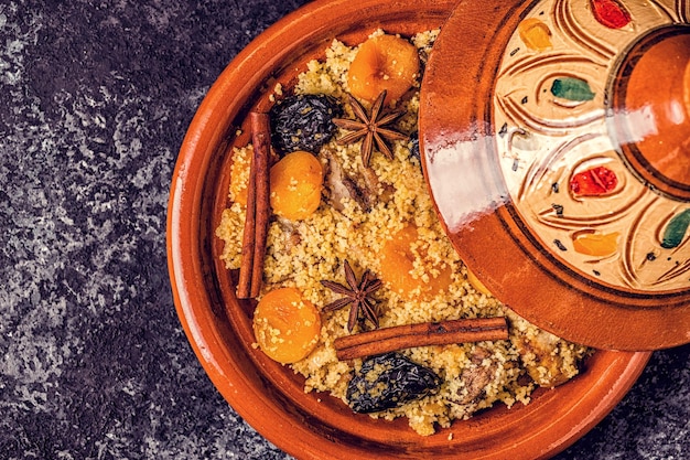 Tajine marocain traditionnel de poulet aux fruits secs et épices