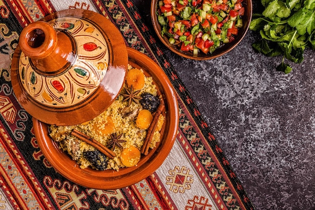 Tajine marocain traditionnel de poulet aux fruits secs et épices