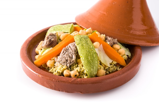 Tajine traditionnel aux légumes, pois chiches, viande et couscous isolé sur une surface blanche