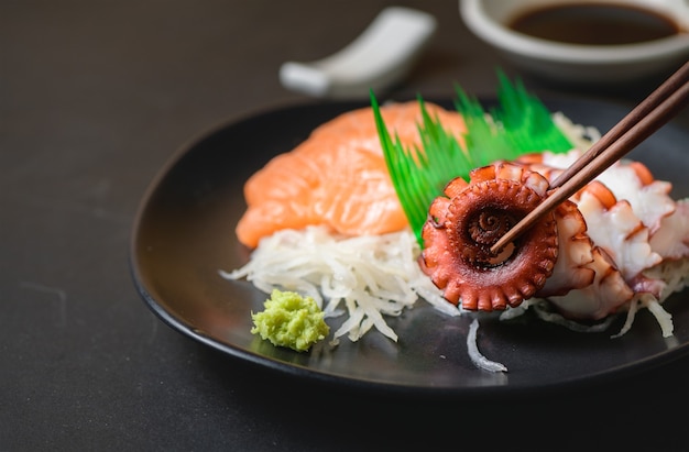 Tako sashimi et saumon sur une plaque noire