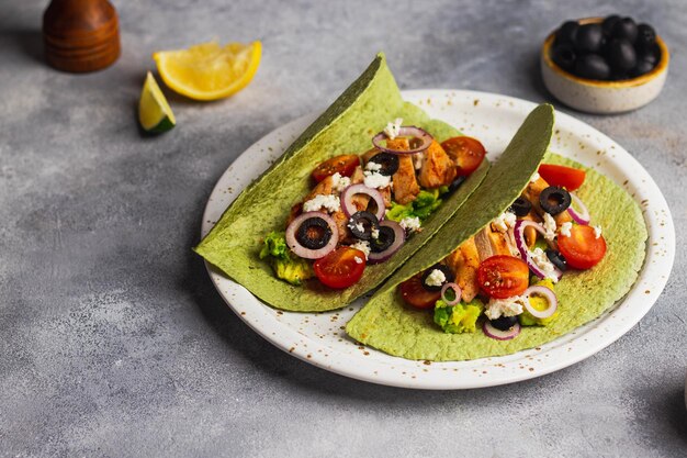 Takos Avec Guacamole, Poulet Frit, Fromage Cottage, Tomate, Oignon Rouge, Ail, Olives En Tortilla Verte Avec Basilic Et épinards. Vue De Dessus Avec Fond