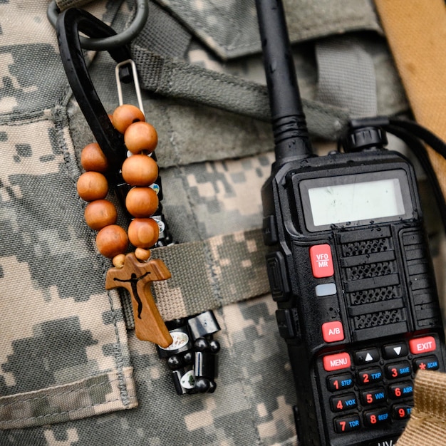 Talkie-walkie et chapelet avec une croix dans la poitrine d'un soldat guerre et foi en Dieu