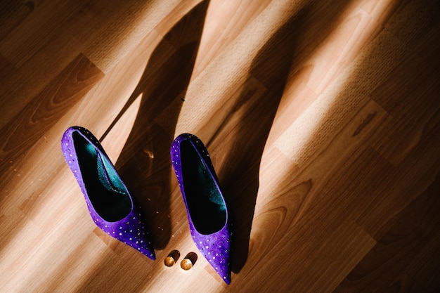 Talons hauts violets et bagues isolés sur un fond pastel marron Concept de mode défilé Chaussures violettes Chaussures pour femmes Silhouette ombre soleil Vue de dessus