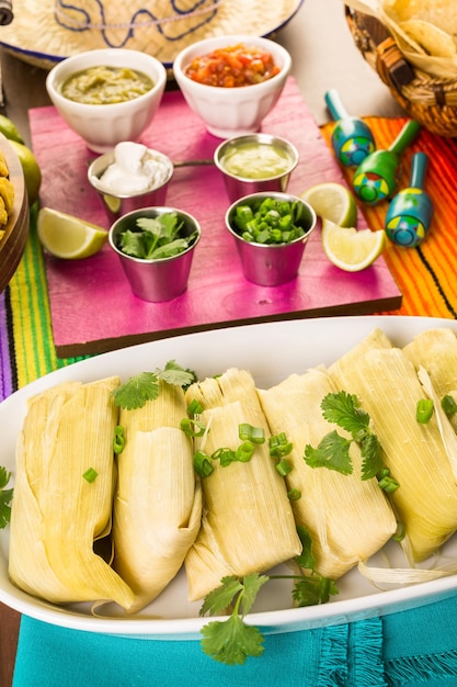 Tamales faits maison sur une assiette de service sur la table de fête.