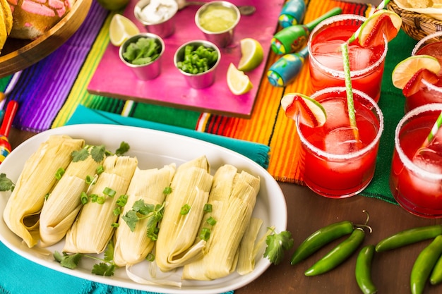 Tamales faits maison sur une assiette de service sur la table de fête.