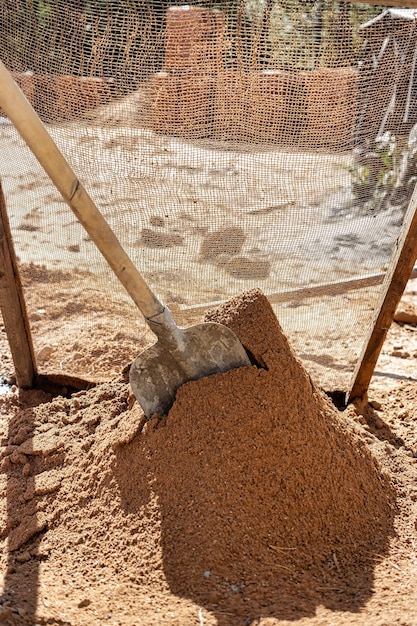 Tamiser le sable pour le mortier sur le chantier Purification du sable des impuretés pour la préparation du mortier pour la maçonnerie ou le plâtrage des murs