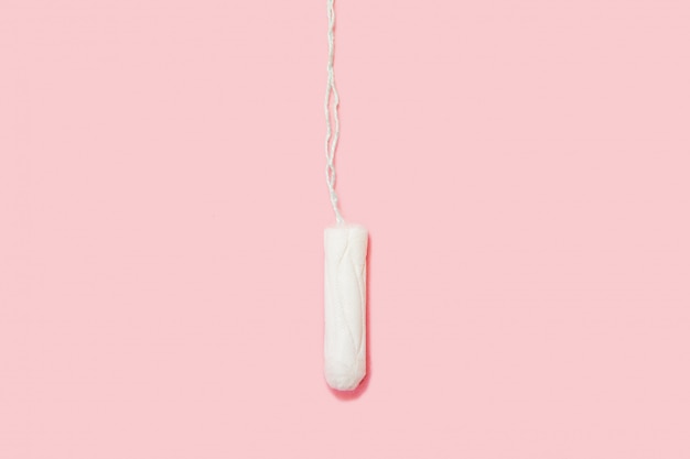 Tampon blanc sur fond rose. Isolé sur rose. Hygiène et santé de la femme