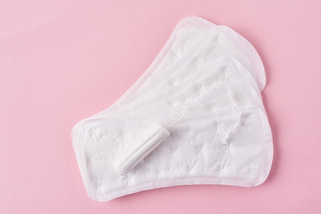 Photo tampon hygiénique et tampon menstruel sur fond rose
