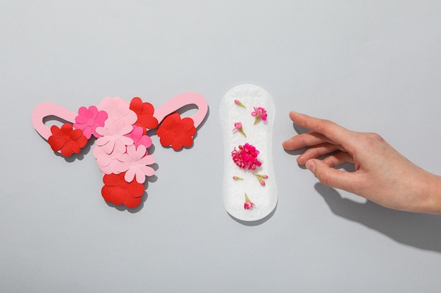 Tampon menstruel avec des fleurs sur fond gris