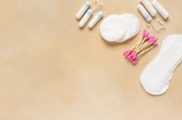 Photo tampons en coton bâtonnets d'oreille et tampons menstruels sur fond beige espace pour le texte