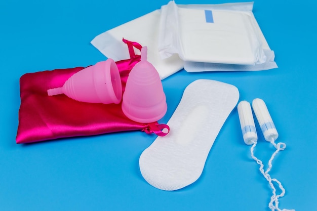 Tampons hygiéniques et coupe menstruelle sur fond bleu Concept de jours critiques menstruation hygiène féminine