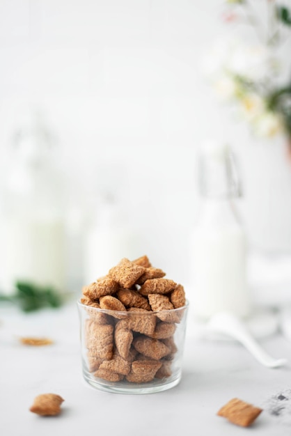 Tampons de maïs au chocolat sucré avec du lait dans une tasse en verre gros plan