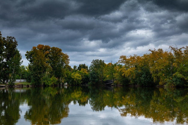 Étang pittoresque dans le parc d'automne par temps nuageux