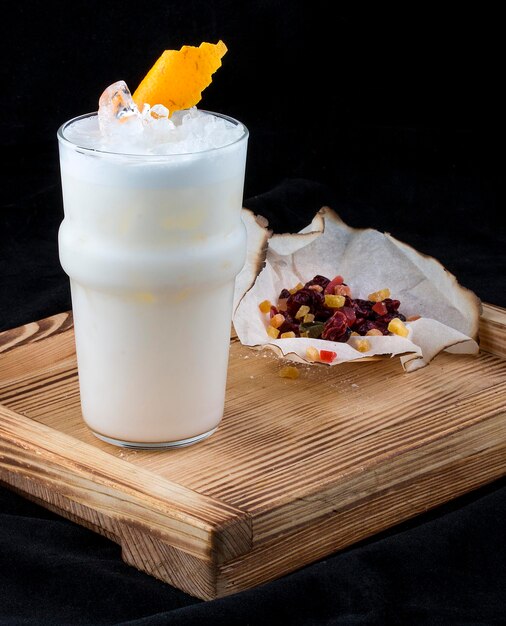 Tangerine Sauer sur une planche de bois avec des fruits confits sur fond sombre