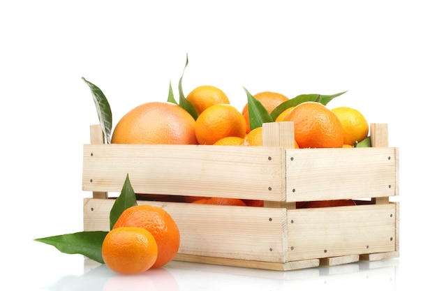 Tangerines savoureuses mûres avec des feuilles dans une boîte en bois isolated on white