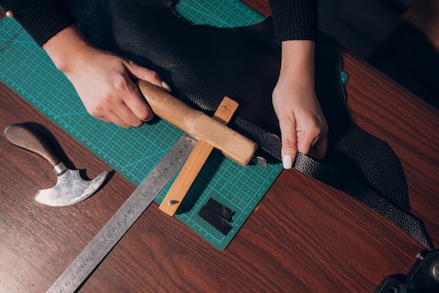 Tanneur femme coupant des articles en cuir sur l'atelier Processus de travail de l'artisan du cuir