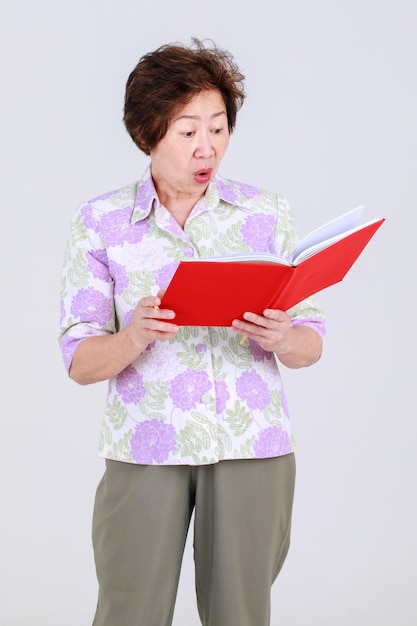 Tante âgée, enseignante âgée de femme asiatique senior enregistrant une idée créative en écrivant une note sur le tableau de notes sur le concept de fond blanc