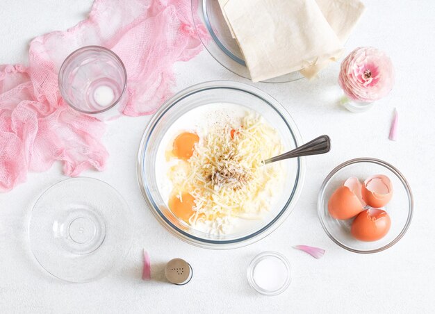 Étape 4 Mélanger les œufs avec du lait de fromage cottage, du fromage râpé et des épices sur la table