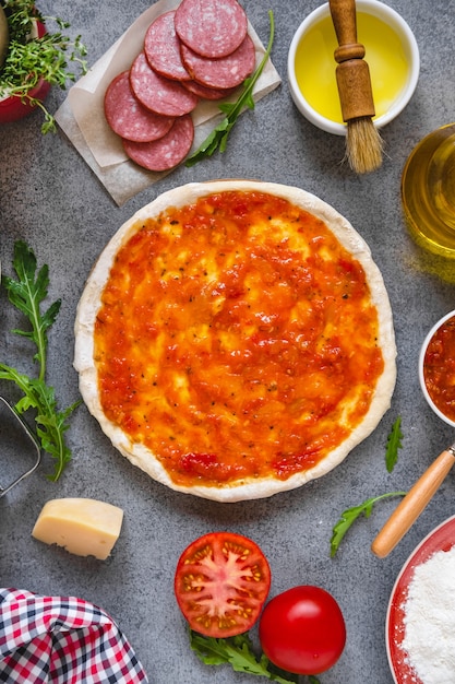 Étape par étape fait une pizza margarita. Ingrédients de la pâte et de la pizza. La cuisson de la pizza italienne sur une table sombre.