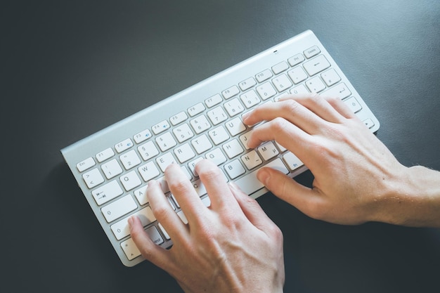 Taper des doigts sur une entreprise en ligne de clavier blanc