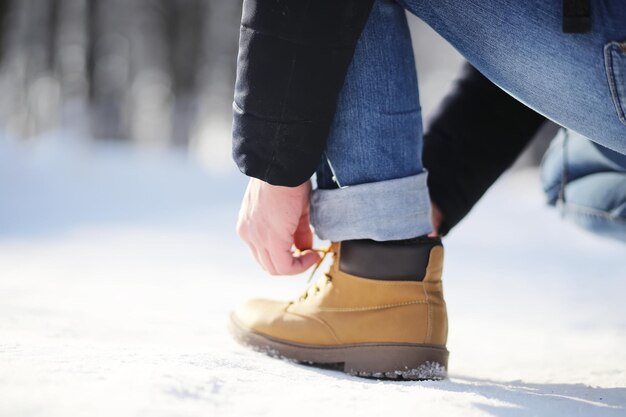 Étapes le long du chemin enneigé. Un homme marche dans le parc en hiver.