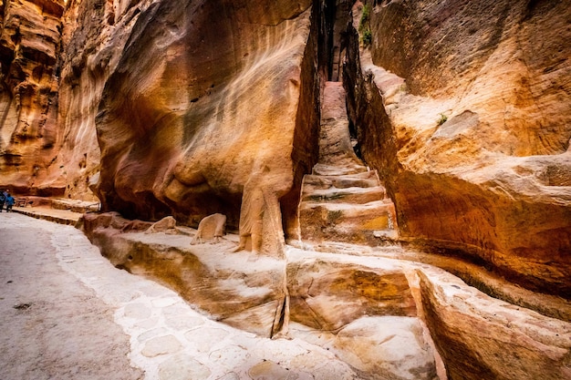 Étapes sculptées dans les roches de grès rouge dans le chemin étroit de Petra en Jordanie