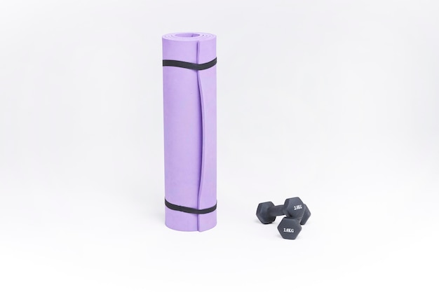 tapis de fitness et haltères haltères noirs et un tapis de yoga violet