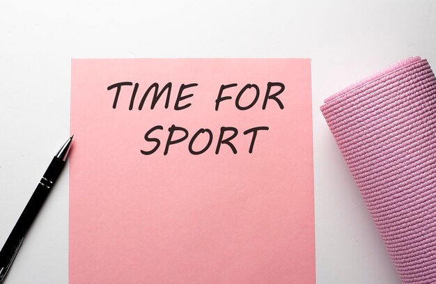 Photo tapis de gym rose et papier rose avec texte time for sport sur fond blanc