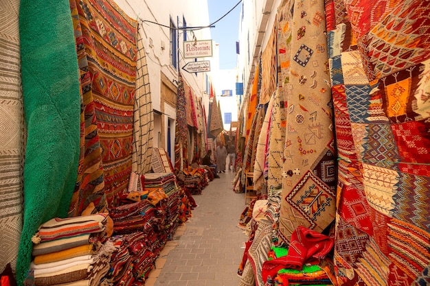 Tapis marocains aux couleurs vives à vendre dans une rue étroite d'Essaouira au Maroc