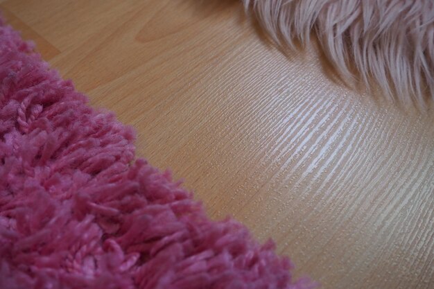 Tapis à poils longs en rose sur un sol stratifié beige Intérieur féminin pour une chambre ou une chambre d'une fille ou d'une femme Design d'intérieur dans des tons roses Le sol est en stratifié Le rôle des acariens dans les allergies