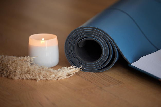 Tapis de yoga et bougies allumées au sol