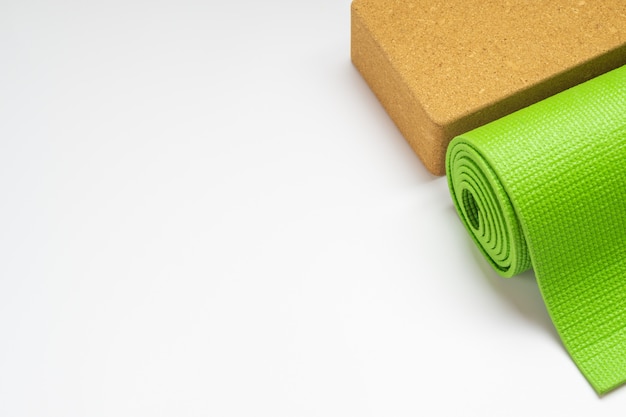 Tapis de yoga vert et blocs de yoga sur blanc